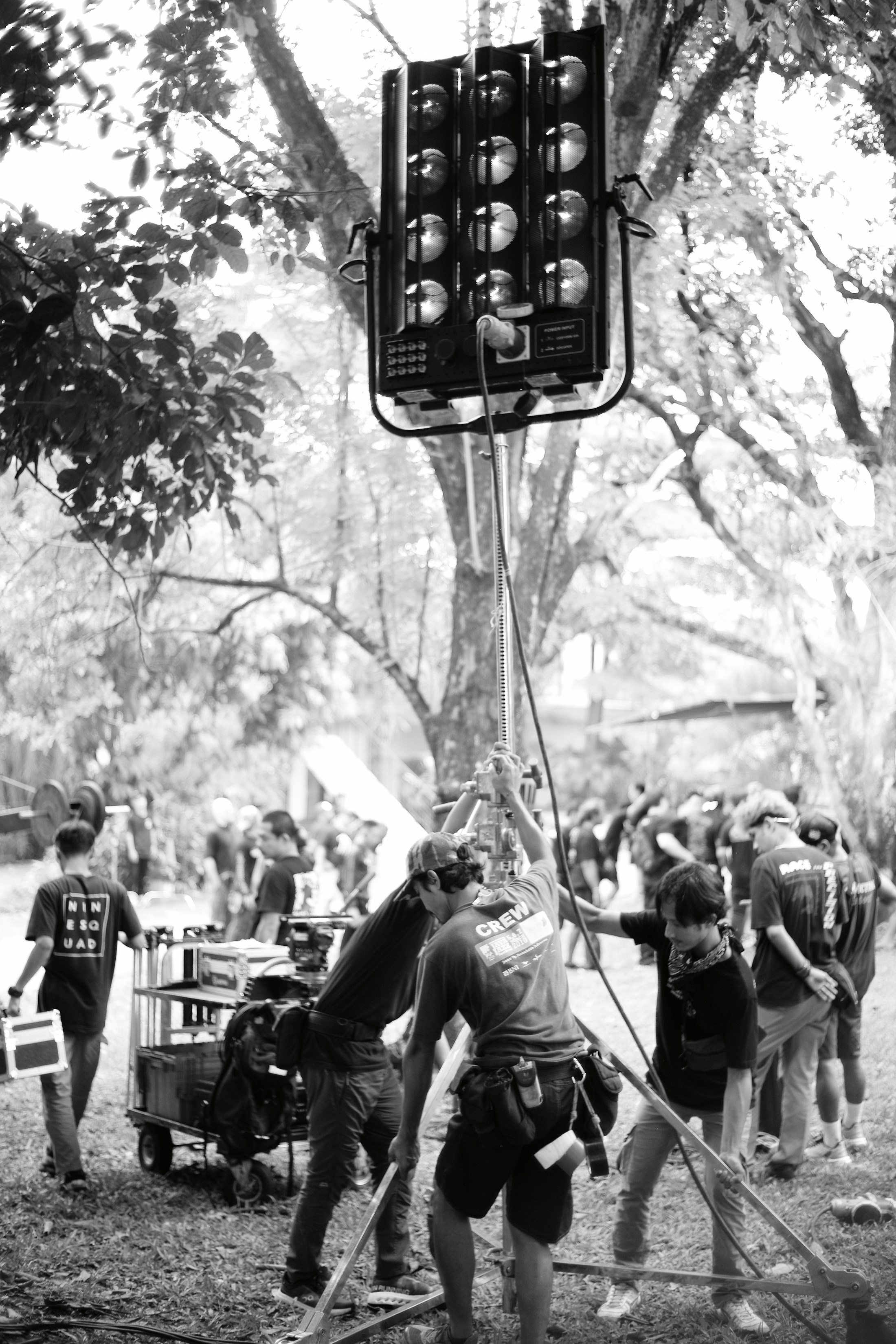 Film crew setting up a large production light on location